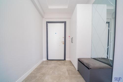 un pasillo con una puerta y un banco en una habitación en ELEGANCE PRESTİGE en Kayseri