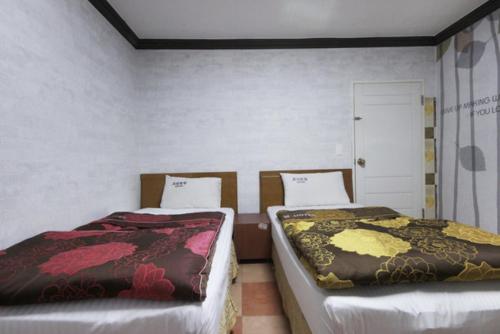 Dream of City Motel في دايغو: سريرين يجلسون بجانب بعض في غرفة