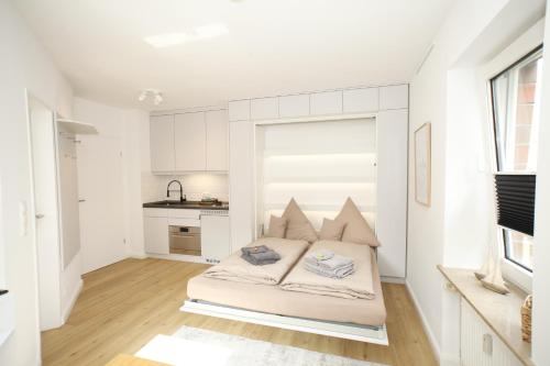 ein weißes Schlafzimmer mit einem Bett in einem Zimmer in der Unterkunft Kapitän's Koje Wangerooge in Wangerooge