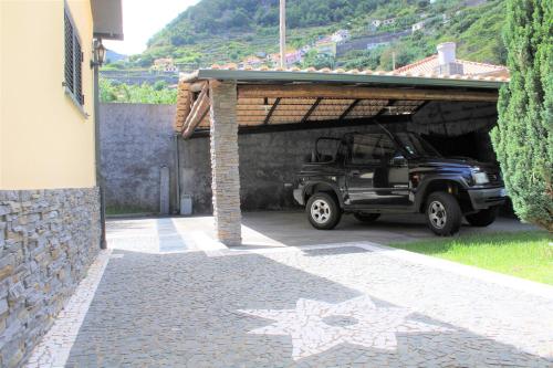 um jipe preto estacionado debaixo de uma garagem em MORADIA - VIEIRA em Machico