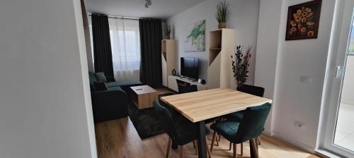 un piccolo appartamento con tavolo e soggiorno di Rooftop condo 45 a Braşov
