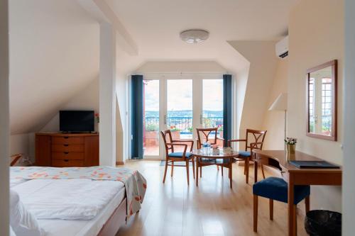 Schlafzimmer mit einem Bett, einem Tisch und Stühlen in der Unterkunft Hotel Orion in Prag