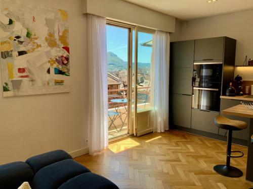 un salon avec un canapé bleu et une grande fenêtre dans l'établissement Le 21 Favre, Hyper centre, 70 m², 2 chambres, à Annecy