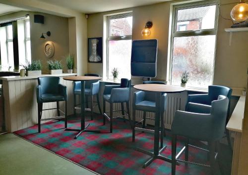 a bar with tables and chairs in a room at Kings Inn Public House 