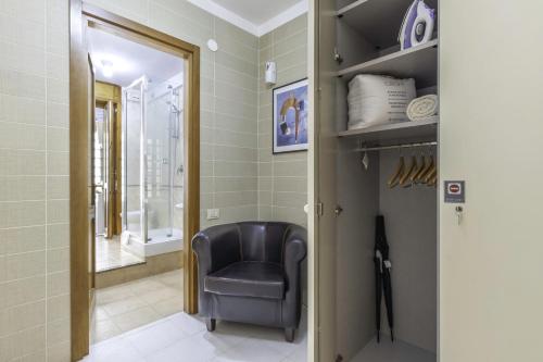 una silla negra en el baño con espejo en Ice Apartment - Free Wifi en Quartu SantʼElena