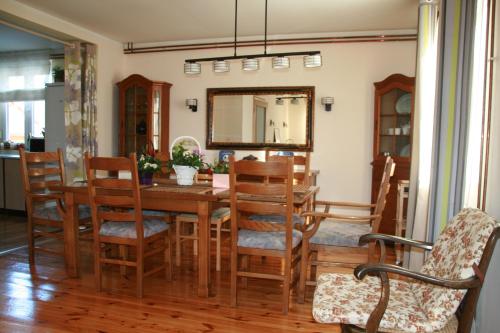 a dining room with a table and chairs and a mirror at Guest House Sergey in Kolašin