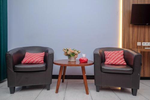 2 sillas y una mesa en una habitación en RedDoorz At Pondok Eyang Obi Sleman en Yogyakarta