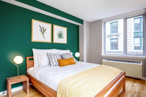 um quarto com uma parede em tons de verde e uma cama em Chelsea 1BR w Roof deck Gym Doorman NYC-122 em Nova York
