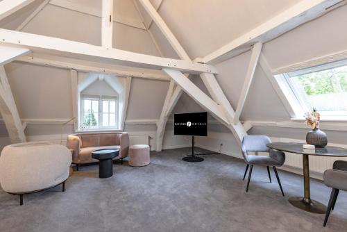 a room with chairs and a table and a tv at Fletcher Hotel Château De Raay in Baarlo