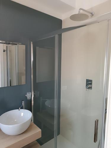 a bathroom with a sink and a glass shower at dalie's house San Leone Centro in Agrigento