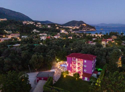 a view of a town at night with a pink building at Ideal House in Parga