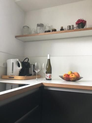a kitchen counter with a bowl of fruit and a bottle of wine at WINETIME in Oberhausen