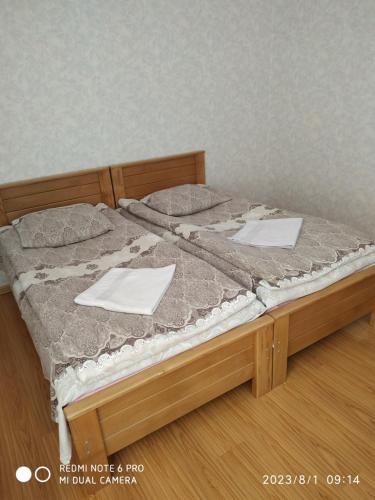 a bed with two sheets and two papers on it at Guest House Besarioni in Borjomi