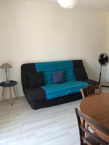un sofá negro sentado en una sala de estar en Appartement lumineux et rénové, en Digne-les-Bains