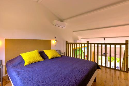 a bedroom with a purple bed with yellow pillows at Atlantic Residence in Jonzac