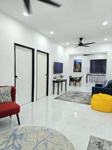 a white living room with a red couch and a ceiling fan at E'dayah Homestay Taman Ria Sungai Petani in Sungai Petani