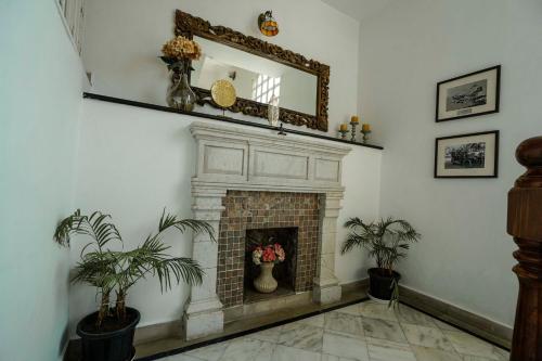 a living room with a fireplace and a mirror at Burj Baneria - A Boutique Homestay in Udaipur