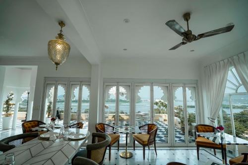 a dining room with a table and chairs and windows at Burj Baneria - A Boutique Homestay in Udaipur