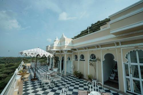 a building with a patio with tables and chairs at Burj Baneria - A Boutique Homestay in Udaipur