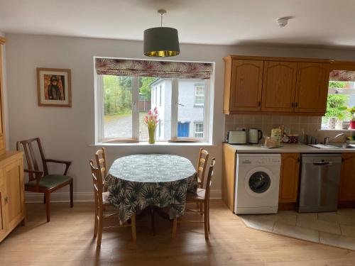 a kitchen with a table and chairs and a window at Garinish Court Maisonette in Glengarriff