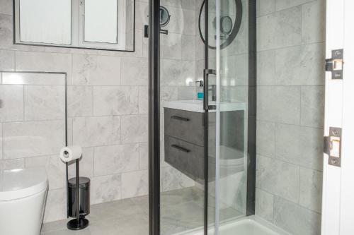 a bathroom with a shower and a toilet at K Suites - 112 Fulbridge Road OLD in Peterborough