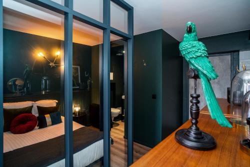 Pokój z łóżkiem z zieloną papugą na stole w obiekcie Elégant appart proche Clinique Marzet - Parking w mieście Pau