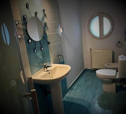 a bathroom with a sink and a toilet and a mirror at Casa de sus in Braşov