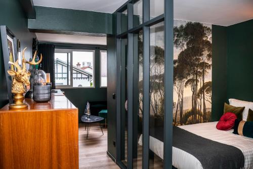 sypialnia z zielonymi ścianami i łóżkiem z drewnianą szafką w obiekcie Elégant appart proche Clinique Marzet - Parking w mieście Pau