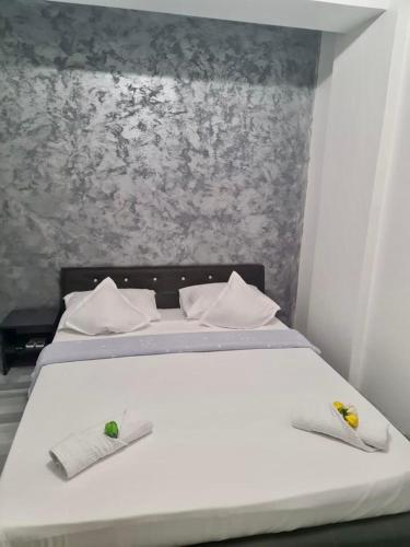 a bedroom with a white bed with two towels on it at Apartament Elysa in Eforie Sud