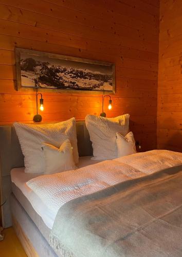 a bedroom with two beds with lights on the wall at Walser Berghüüsle in Hirschegg