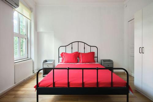 a bedroom with a red bed with two red pillows at Taksim square, galata tower historical flat in Istanbul