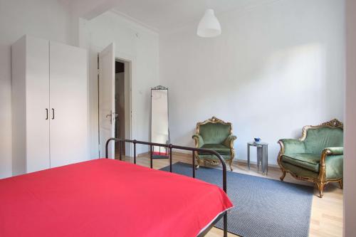 a bedroom with two chairs and a bed with a red blanket at Taksim square, galata tower historical flat in Istanbul