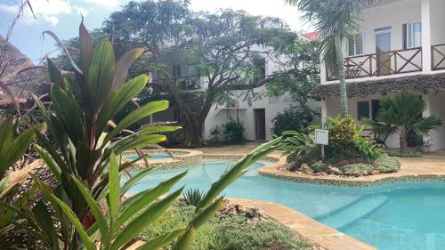 a swimming pool in front of a building at Kibanda Lodge and Beach Club in Nungwi