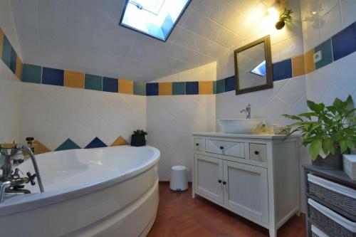 ein Badezimmer mit einer großen Badewanne und einem Waschbecken in der Unterkunft Chambre d'hôtes L'altitude - Domaine la Rose des vents in Castelnau-sur-lʼAuvignon