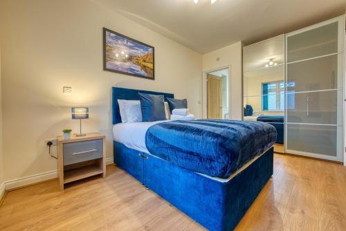 a bedroom with a blue bed and a glass shower at K Suites - The Villas in Birmingham