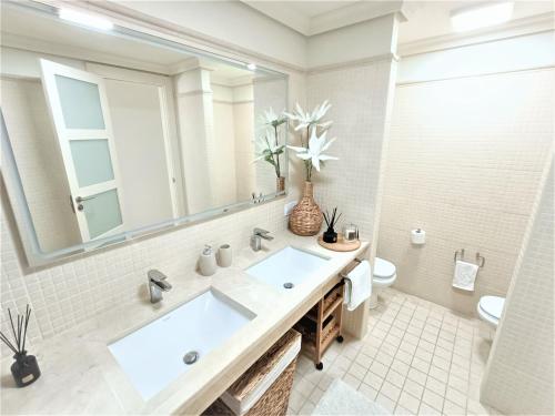 een badkamer met een wastafel, een spiegel en een toilet bij Luxury Los Gigantes Apartment in Puerto de Santiago