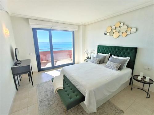 Un dormitorio con una cama grande con vista al mar. en Luxury Los Gigantes Apartment, en Puerto de Santiago