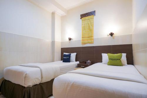 a hotel room with two beds and a window at Urbanview Hotel 58 Bintaro by RedDoorz in Pondoklang