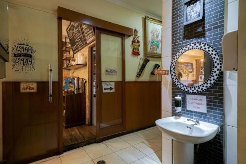 a bathroom with a sink and a mirror at Urbanview Hotel 58 Bintaro by RedDoorz in Pondoklang