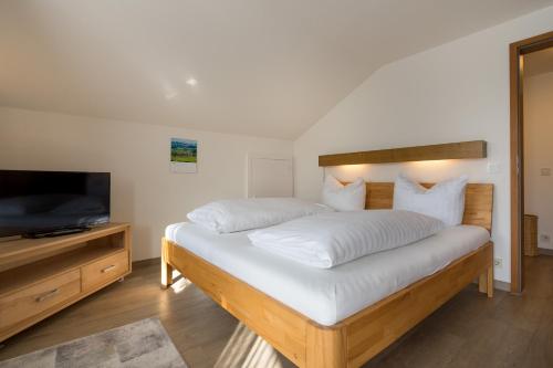 een slaapkamer met een groot bed en een televisie bij Ferienwohnung Laux in Oberstdorf