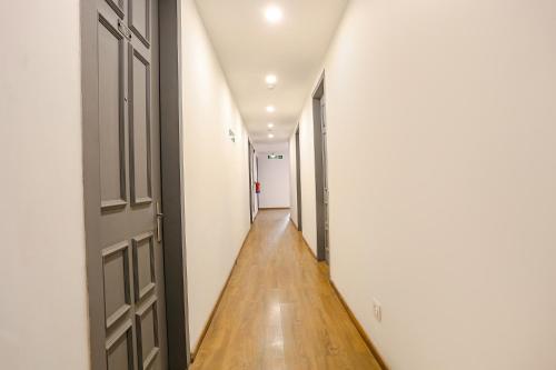 um corredor vazio com uma porta aberta e pisos de madeira em FabExpress Hexa Meera Bagh em Nova Deli