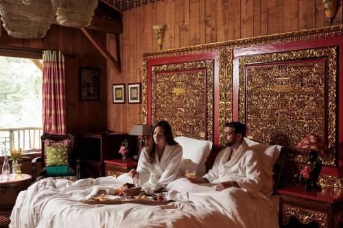 Ein Mann und eine Frau sitzen im Bett in der Unterkunft Chateau Du Boisniard in Chambretaud