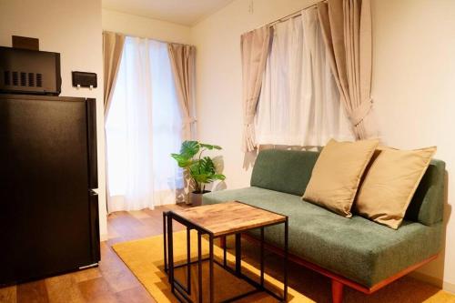 大阪市にあるリエゾンコートユニバーサルゲートウェイ - Free Parkingの緑のソファとテーブルのあるリビングルーム