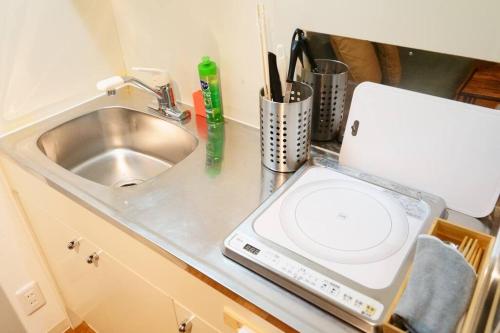 a kitchen counter with a sink and a washing machine at Liaison Court Universal Gateway - Free Parking in Osaka