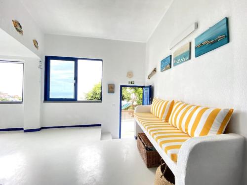sala de estar con sofá blanco y amarillo en Casa Santorini, en Ribeira Brava