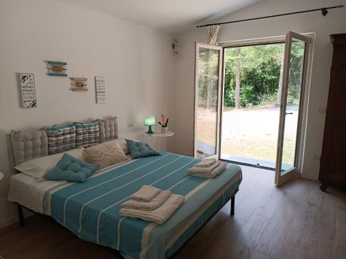 1 dormitorio con 1 cama grande y toallas. en Sorgenti nel bosco Appartamento vista lago, en Campo Reggiano