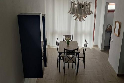 a dining room with a table and chairs and a chandelier at NiMa in Cagliari