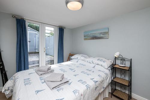 a bedroom with a bed and a large window at Tan Y Wylan in Rhosneigr