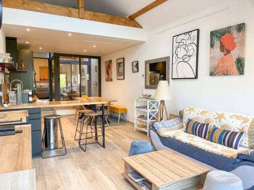 un salon avec un canapé et une cuisine dans l'établissement Le Loft à deux pas du Lac, à Talloires