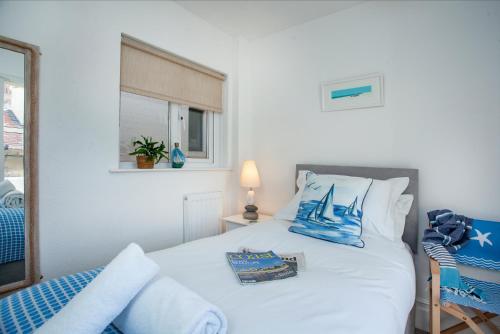 a bedroom with a bed with a sailboat on it at Pebbles In Budleigh in Budleigh Salterton